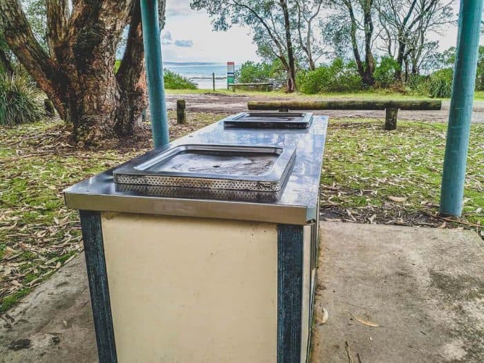 public bbq in a park with the beach in the background
